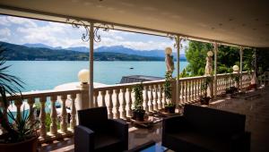 沃尔特湖畔佩莎赫波尔西亚观景酒店的享有湖泊和山脉美景的阳台。