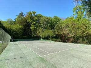 尚蒂伊Manoir des Cavaliers - BnB的一座树木林立的网球场