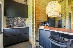 迪森Appel Lodge的厨房设有酒吧、黑色橱柜和吊灯。