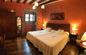 Ziga卡萨乡村兹盖克艾特克斯兹日酒店的一间设有两张床铺的卧室,位于带红色墙壁的房间