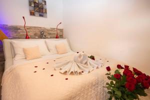 多布日什Romantický wellness suite hotel Heinz的一间卧室,床上有红色玫瑰
