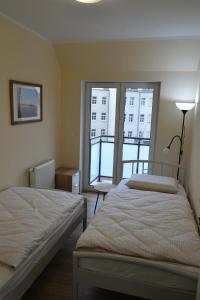 莱什诺Leszno City Center Apartments的一间卧室设有两张床和大窗户