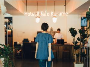 久留米市Hostel ilfaro Kurume的带着手提箱在商店里走的女人