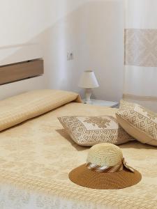 卡拉古诺内Apartment Stella Maris的两张带枕头和顶部帽子的床