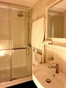 措芬根罗姆巴德酒店的带淋浴、盥洗盆和镜子的浴室