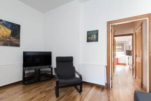 爱丁堡Castle Vista, Grassmarket Apartment的客厅配有椅子和电视