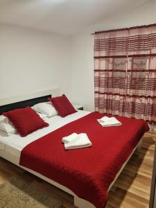 Kaštel SućuracApartman Nela的一间卧室配有红色大床和毛巾