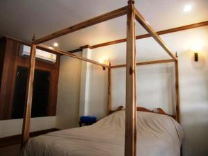 曼谷皇家查亭度假村酒店的卧室内的一张木制四柱床