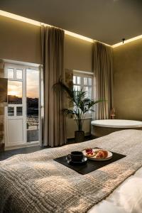 干尼亚Divino Suites Chania的一间卧室,配有一张带一盘食物的床