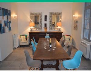 PuilaurensLe Petit Chateau的一间带桌椅和镜子的用餐室