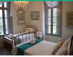PuilaurensLe Petit Chateau的一间卧室设有两张床和两个窗户。
