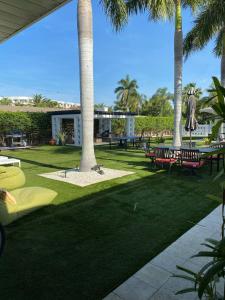 萨拉索塔Captiva Beach Resort (open private beach access)的棕榈树公园,长凳和桌子