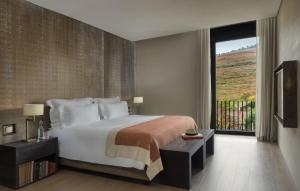 拉梅戈杜罗河谷六善酒店的一间卧室设有一张大床和一个大窗户