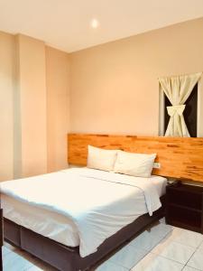 先达安达酒店的卧室设有一张白色大床和一扇窗户。