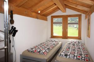 克洛斯特斯Gotschnablick的客房设有两张床和窗户。