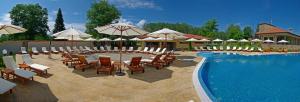 加布罗沃Къща Наковски的毗邻度假酒店的带椅子和遮阳伞的游泳池