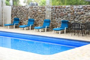 里奥韦尔德Hotel El Molino的一组椅子和桌子,位于游泳池旁