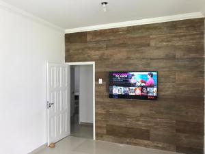 马拉戈日Ampla Casa na beira mar de Maragogi的客厅设有木墙,配有电视。