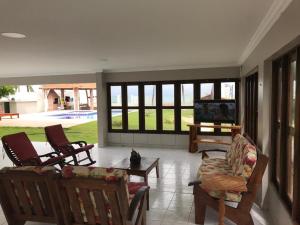 马拉戈日Ampla Casa na beira mar de Maragogi的客厅配有椅子、电视和沙发