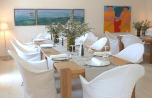 瓦西埃利斯酒店的一间带桌子和白色椅子的用餐室