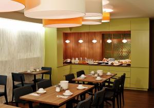 德赖艾希亨利酒店的餐厅设有木桌、椅子和柜台