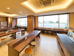 神栖市Super Hotel Kashima的餐厅设有桌子、凳子和大窗户