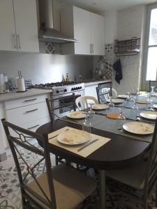 穆瓦萨克Auberge des chemins的厨房配有带盘子和玻璃杯的桌子