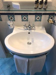阿马尔菲Amalfitano Apartments的浴室设有蓝色瓷砖,配有白色水槽。