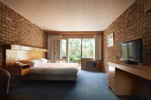 福林德斯弗林德斯湾汽车旅馆 的一间卧室设有床铺、电视和砖墙