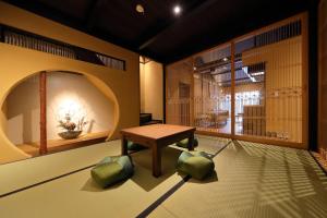 京都Kyo no oozora SAIKA的配有木桌和绿色靠垫的客房
