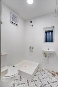 雅加达Capital O 3300 Nadjara Residence Syariah的白色的浴室设有卫生间和水槽。