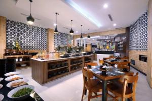 万隆Neo Dipatiukur Bandung by ASTON的一间带桌椅的餐厅和一间厨房