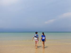 柴老海滩班茵索克度假酒店的两个人在海滩上水中散步