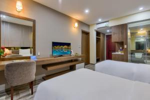 洞海MANLI Resort Quảng Bình的一间卧室配有一张床和一张书桌及电视