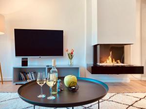 宾茨Prora Düne 7的客厅设有壁炉和带酒杯的桌子