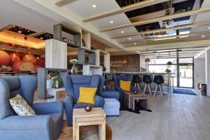 马达伯乐斯拉夫哥仑特酒店的客厅设有蓝色椅子和酒吧