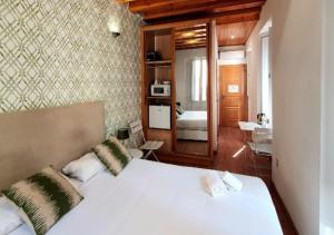 瓦伦西亚Mercat Suites的一间带白色大床的卧室和一间浴室