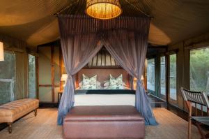 阿马卡拉保护区HillsNek Safari Camp – Amakhala Game Reserve的一间卧室配有一张带天蓬的床