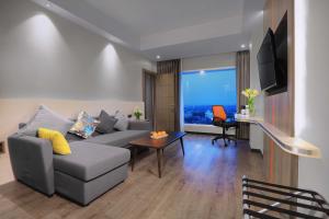 棉兰Harper Wahid Hasyim Medan by ASTON的客厅配有沙发和桌子