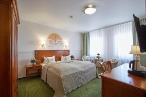 巴登-巴登Hotel Beek by Anna的配有一张床和一张书桌的酒店客房