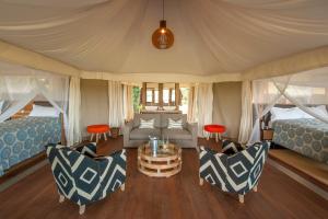 KakumbiChikunto Safari Lodge的一间设有两张床和一张桌子及椅子的房间
