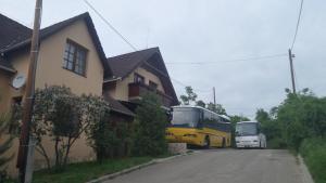 埃格尔勒加尼公寓酒店的两辆公共汽车停在房子旁边的街道上