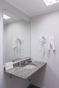 圣保罗罗哈斯全套房酒店的一间带水槽和大镜子的浴室