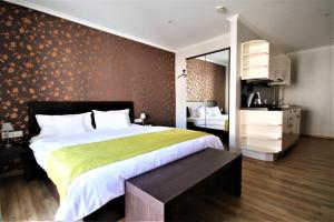 布莱费里恩多米奇尔阿姆林登普拉兹酒店的一间卧室配有一张带绿毯的大床