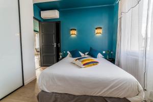 布里夫拉盖亚尔德LABRUNIE #6 - Espace chic et nature - 2 Chambres的卧室配有白色大床和蓝色的墙壁
