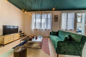 布里夫拉盖亚尔德LABRUNIE #6 - Espace chic et nature - 2 Chambres的客厅配有绿色沙发和电视