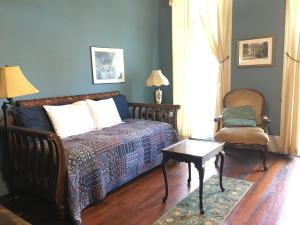 新奥尔良Garden District Bed and Breakfast的一间卧室配有一张床、一把椅子和一张桌子
