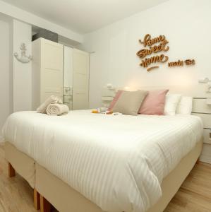 潘普洛纳Home Sweet Home Main St Pamplona的卧室配有一张带白色床单和粉红色枕头的大床。