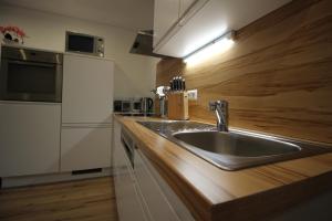 弗拉塔赫Appartementhaus Lercher的厨房配有不锈钢水槽和木制台面