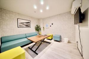 名古屋Guest House Re-worth Joshin1 2F的客厅配有沙发和桌椅
